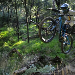 man in blue shirt riding bicycle on forest during daytime