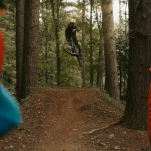 man in black jacket riding bicycle on forest during daytime